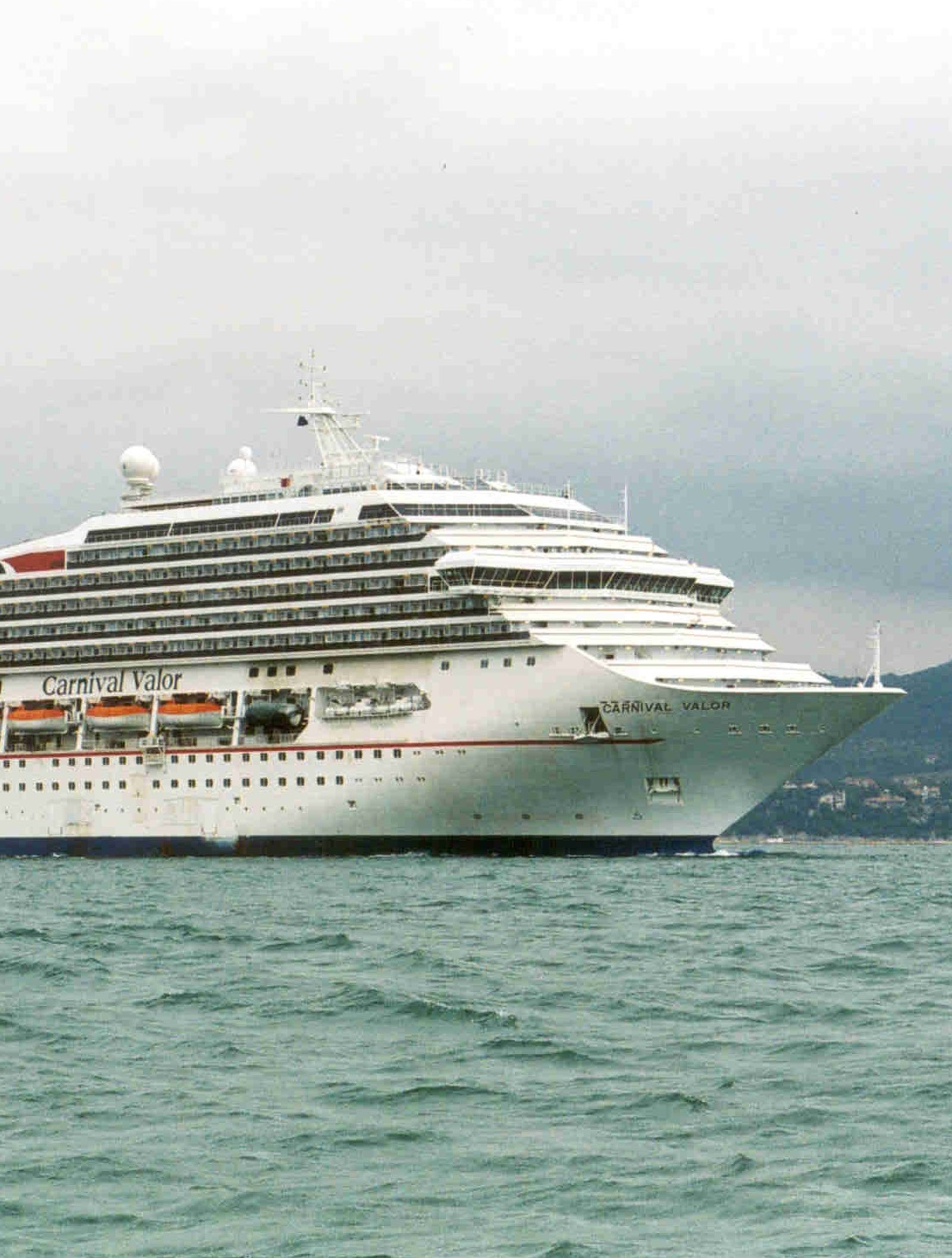  Fincantieri | Gruppo - Business - Prodotti - Navi da Crociera - Carnival Valor: Vista laterale della nave Carnival Valor operativa in navigazione, scafo con ponti multipli e fumaiolo rosso a forma di ala.
