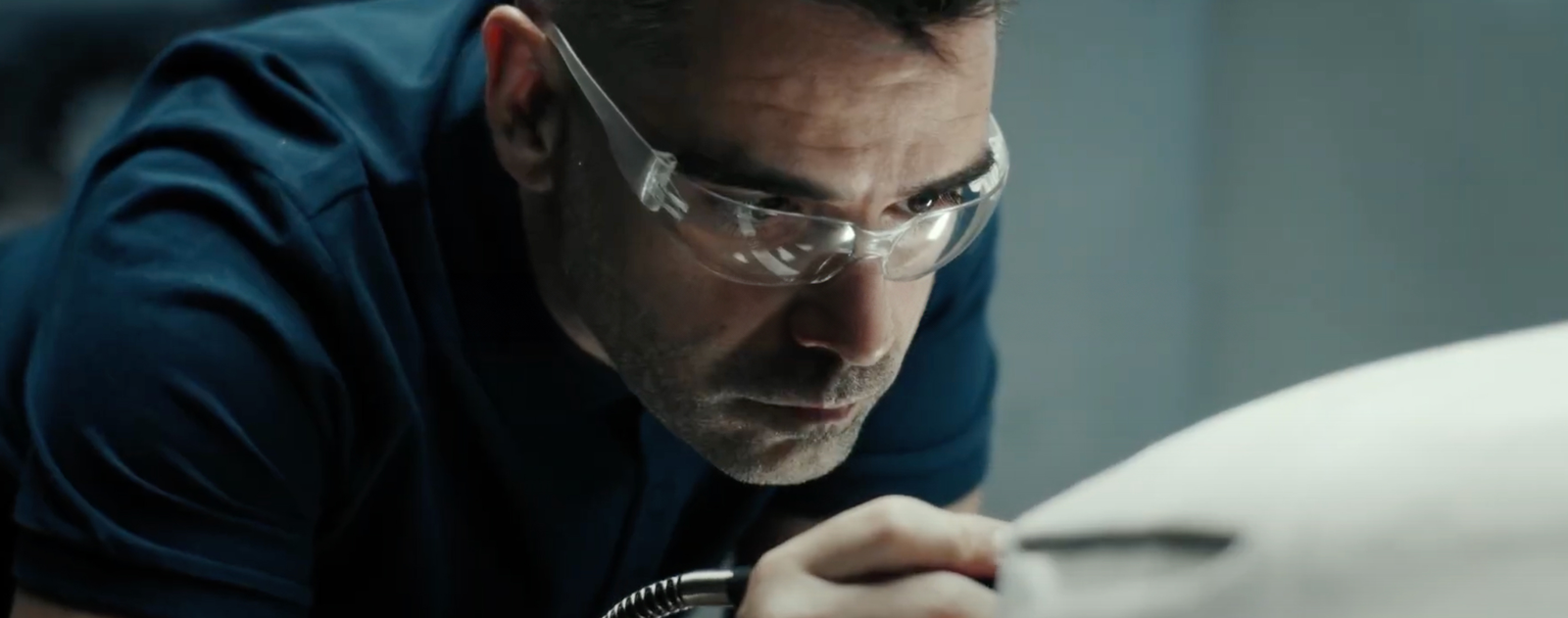 Fincantieri | About Us - Future on Board: Person working on a machine model in a design studio or professional workshop, using a tool to refine details on the surface, environment evoking precision, craftsmanship, and the creative process, with soft lighting.