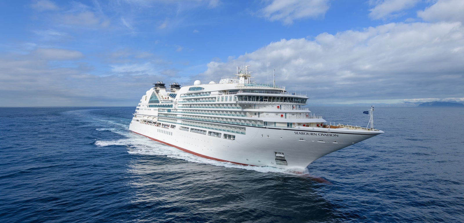 Fincantieri | Group - Business - Products - Cruise Ships - Seabourn Ovation: Side view of Seabourn Ovation cruise ship in operation, white hull with modern design, Seabourn Ovation name visible on side.