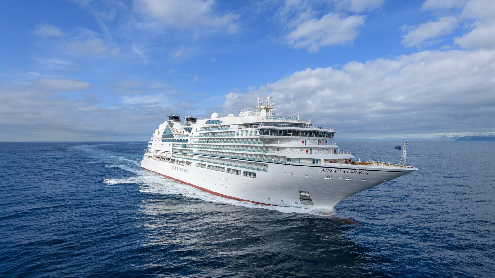Fincantieri | Group - Business - Products - Cruise Ships - Seabourn Ovation: Side view of Seabourn Ovation cruise ship in operation, white hull with modern design, Seabourn Ovation name visible on side.