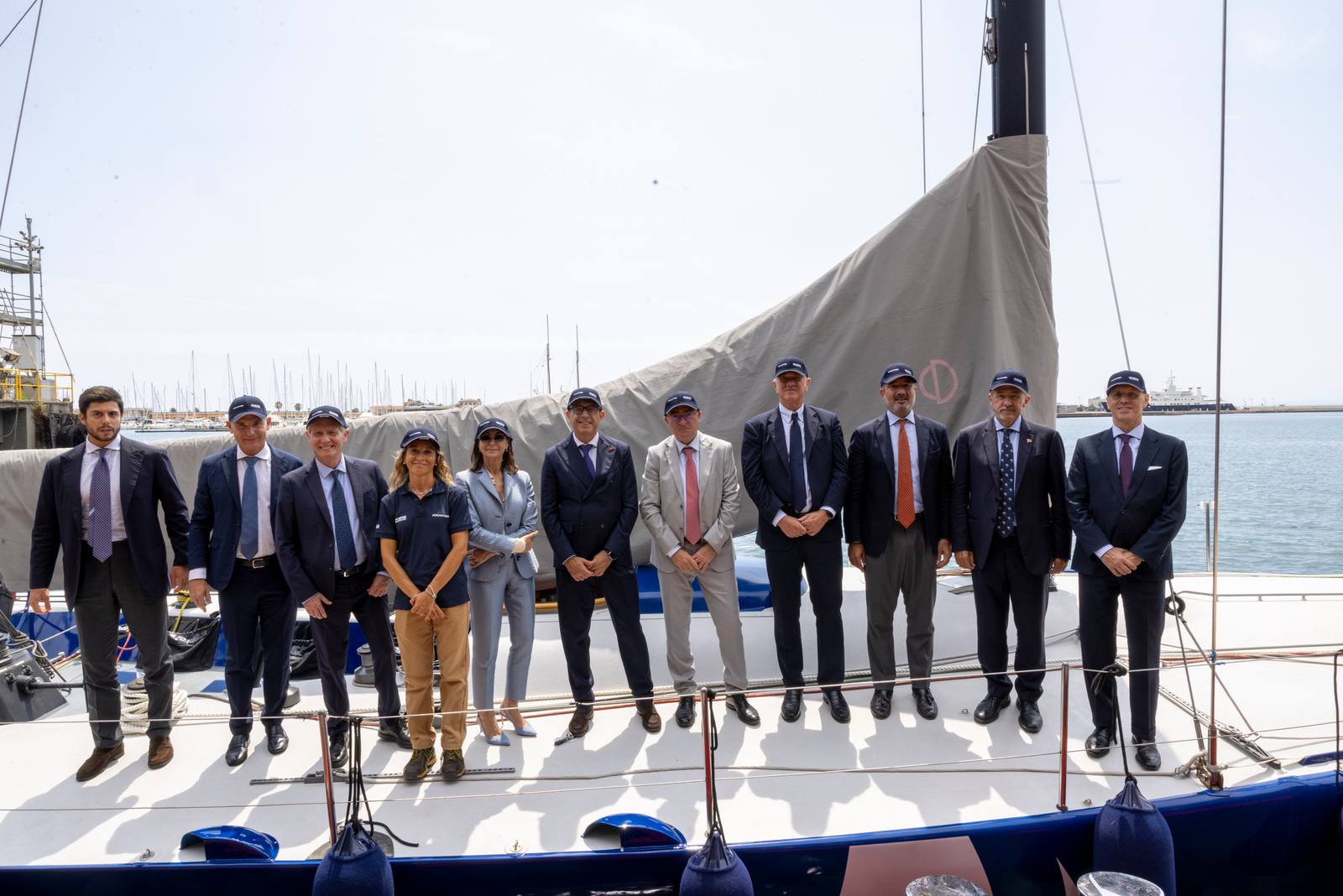 Business delegation posing on docked sailboat