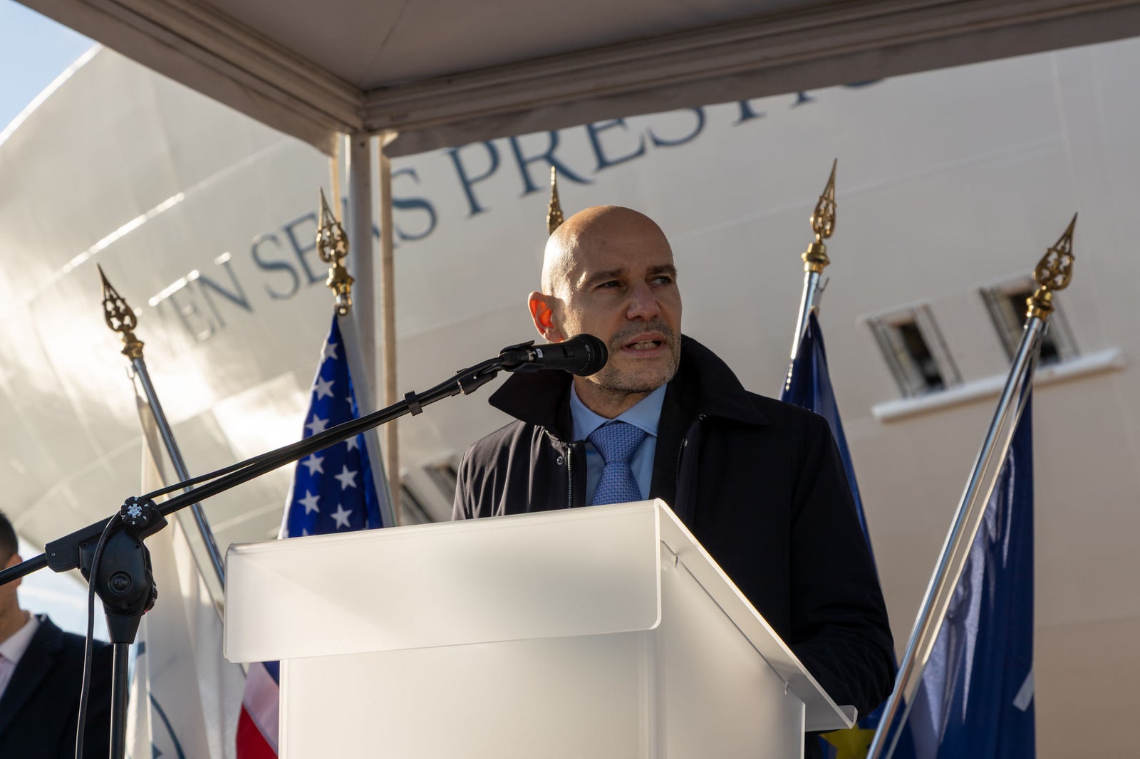 newsroom - press releases - 2025 - fincantieri group: fincantieri seven seas prestige launched in marghera: speaker at podium during launch ceremony, "seven seas prestige" cruise ship bow and international flags in the background.