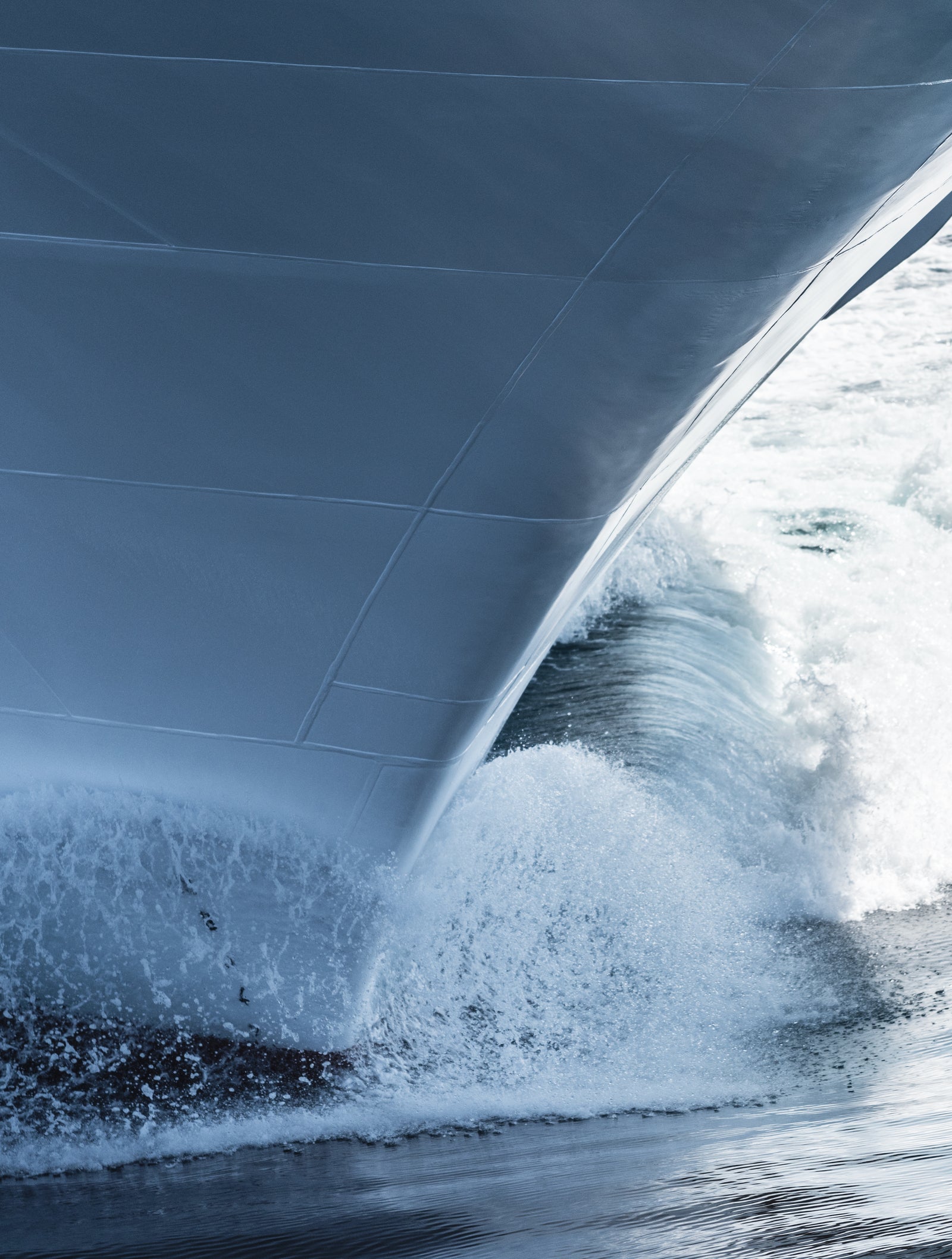  Fincantieri | Gruppo - Business - Prodotti - Navi da Crociera - Seabourn Encore: Primo piano della prua della Seabourn Encore operativa che fende l’acqua creando spruzzi, superficie metallica dello scafo visibile.