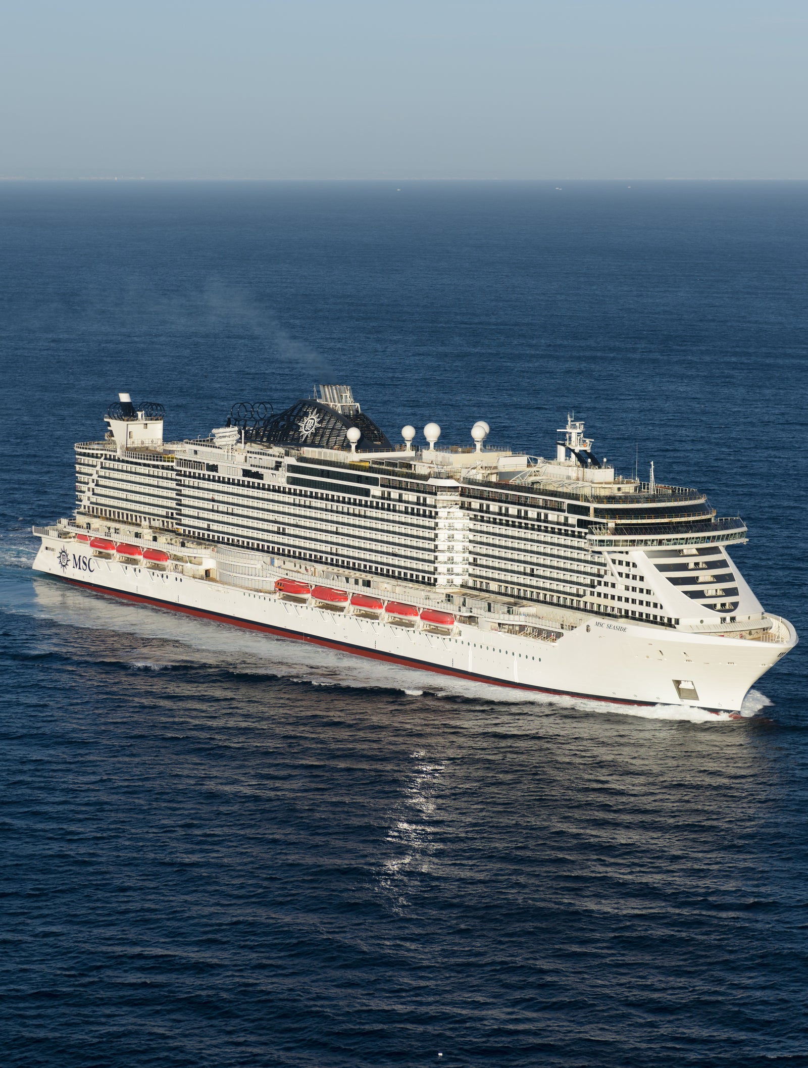 Fincantieri | Group - Business - Products - Cruise Ships - MSC Seaside: Modern cruise ship in operation, white hull with multi-level passenger decks and visible red lifeboats.