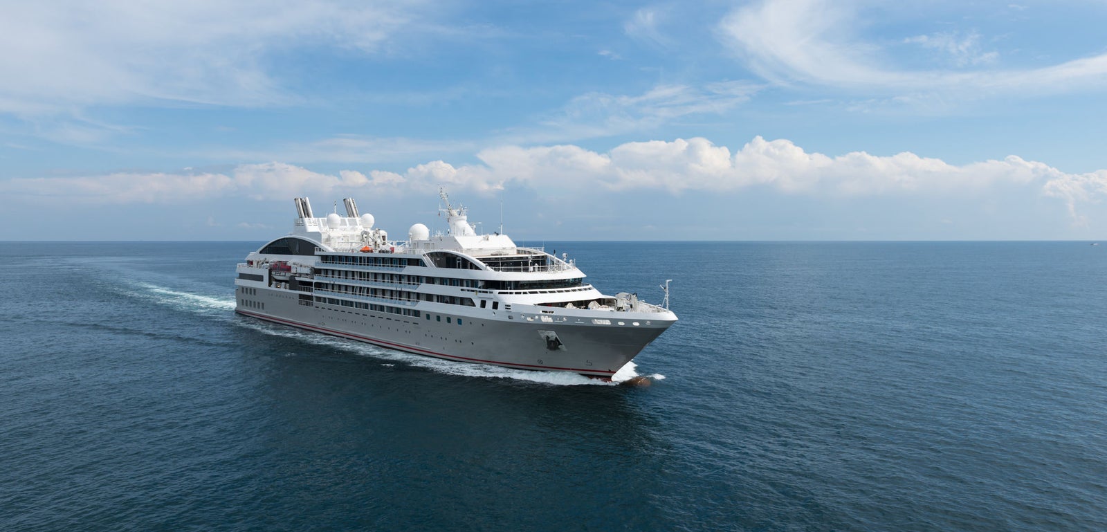 Fincantieri | Group - Business - Products - Cruise Ships - Le Soléal: Side view of Le Soléal cruise ship in operation navigating open sea, white hull, multiple passenger decks, visible lifeboats along sides, clear sky.