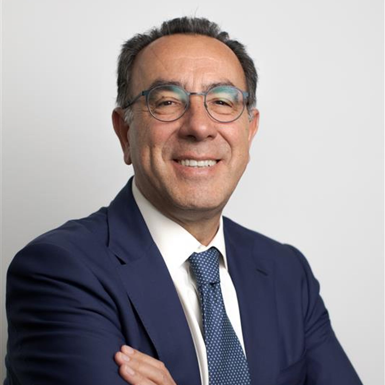 Newsroom - Comunicati stampa - 2026 - Gruppo Fincantieri: Fincantieri è Top Employer Italia per il quinto anno consecutivo: Uomo in abito blu, camicia bianca e cravatta blu con le braccia incrociate, sfondo chiaro neutro, ritratto formale business.