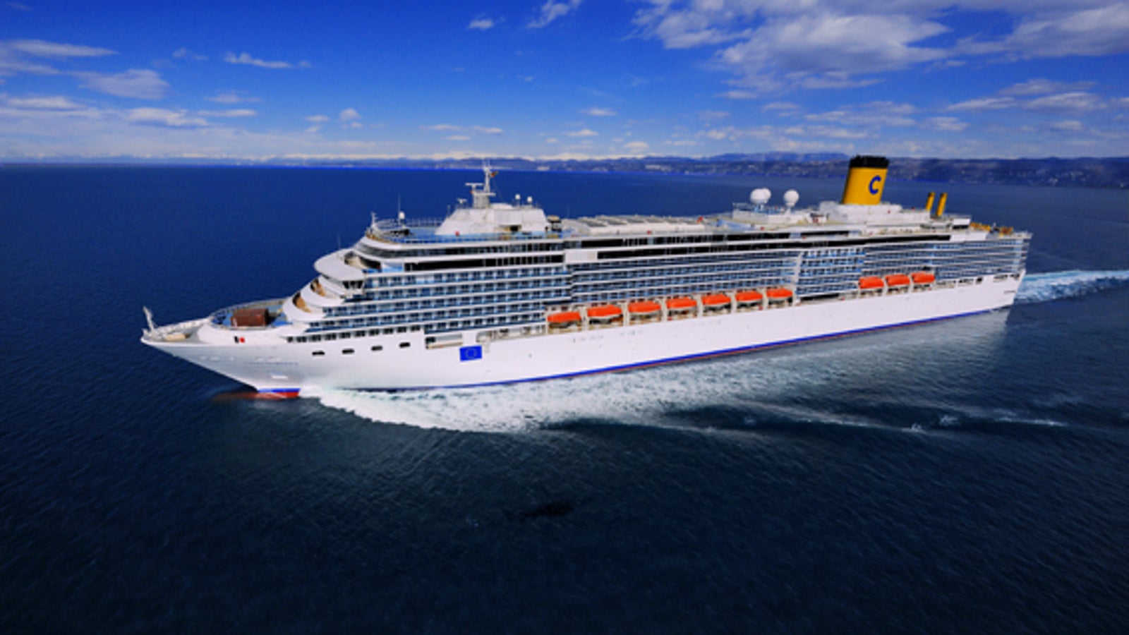 Fincantieri | Gruppo - Business - Prodotti - Navi da Crociera - Costa Luminosa: Grande nave da crociera operativa, vista laterale in navigazione, molteplici ponti, scialuppe di salvataggio, camino giallo distintivo con logo 'C'.