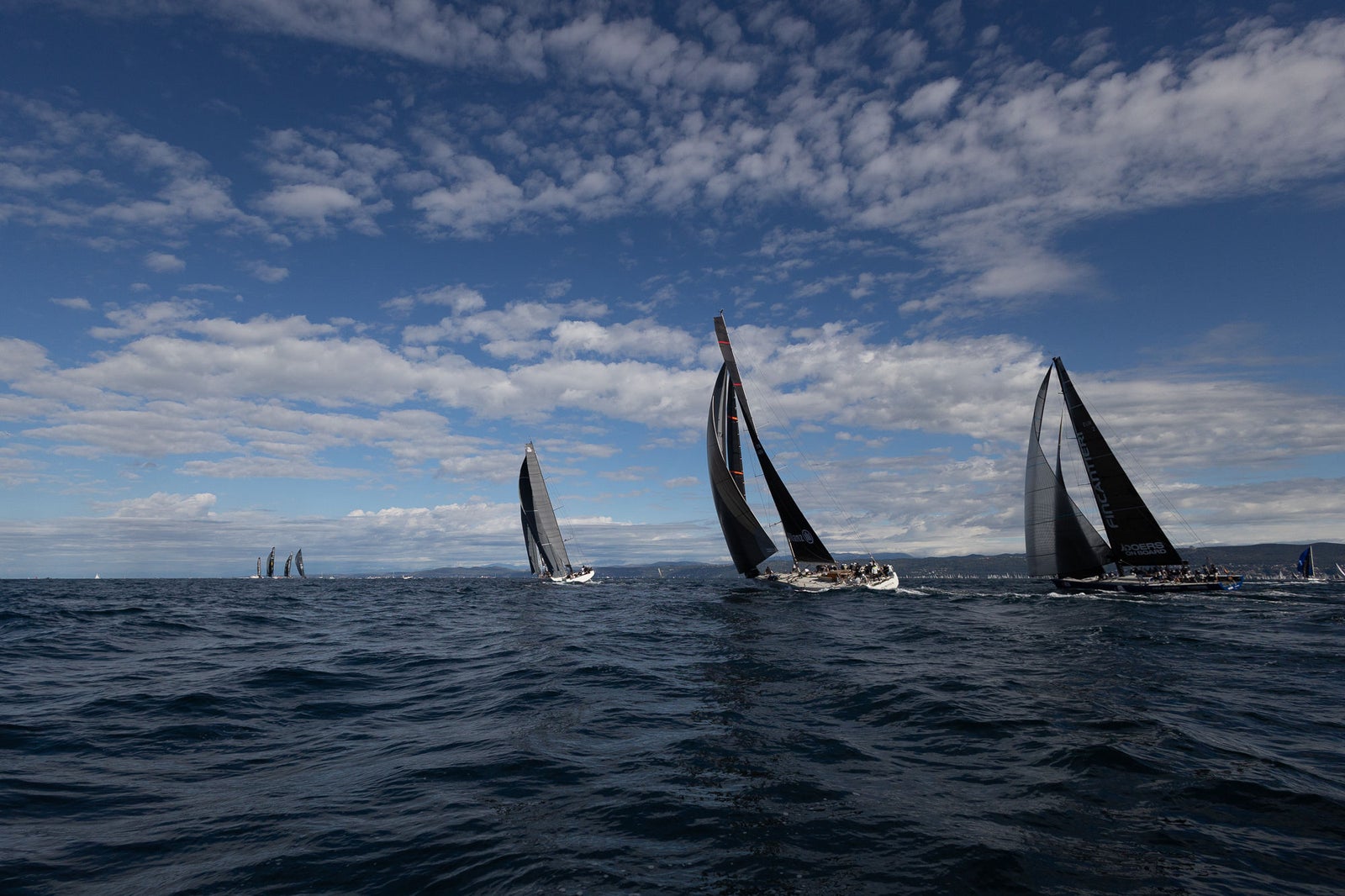 Racing sailboats cutting through open sea