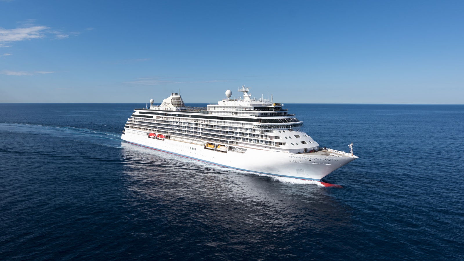 Fincantieri | Gruppo - Business - Prodotti - Navi da Crociera - Seven Seas Explorer: Grande nave operativa con esterni rosso e bianco, scialuppe di salvataggio e radar prominente sulla sommità, nome 'Fram' chiaramente visibile sullo scafo, naviga in acque calme durante un tramonto dorato, illuminazione calda che esalta i dettagli, atmosfera serena e affascinante.