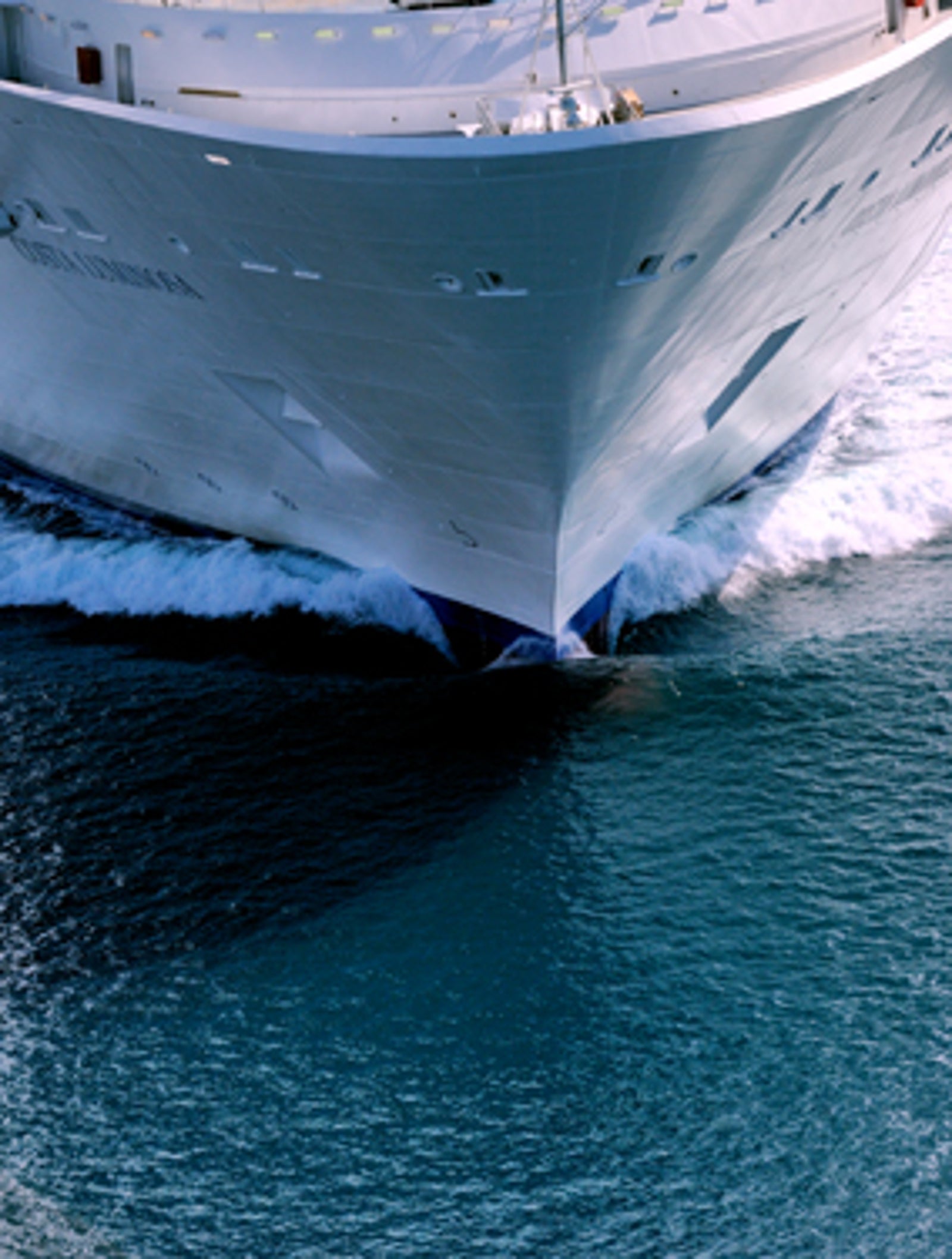 Fincantieri | Gruppo - Business - Prodotti - Navi da Crociera - Costa Luminosa: Grande nave da crociera operativa che scivola su acque blu calme, scia dinamica a prua, design filante ed esterno bianco ben visibili, viaggio marittimo sereno senza passeggeri o equipaggio visibili sul ponte.