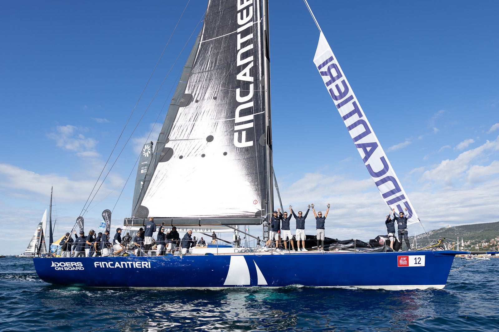 Crew celebrating aboard Fincantieri racing sailboat
