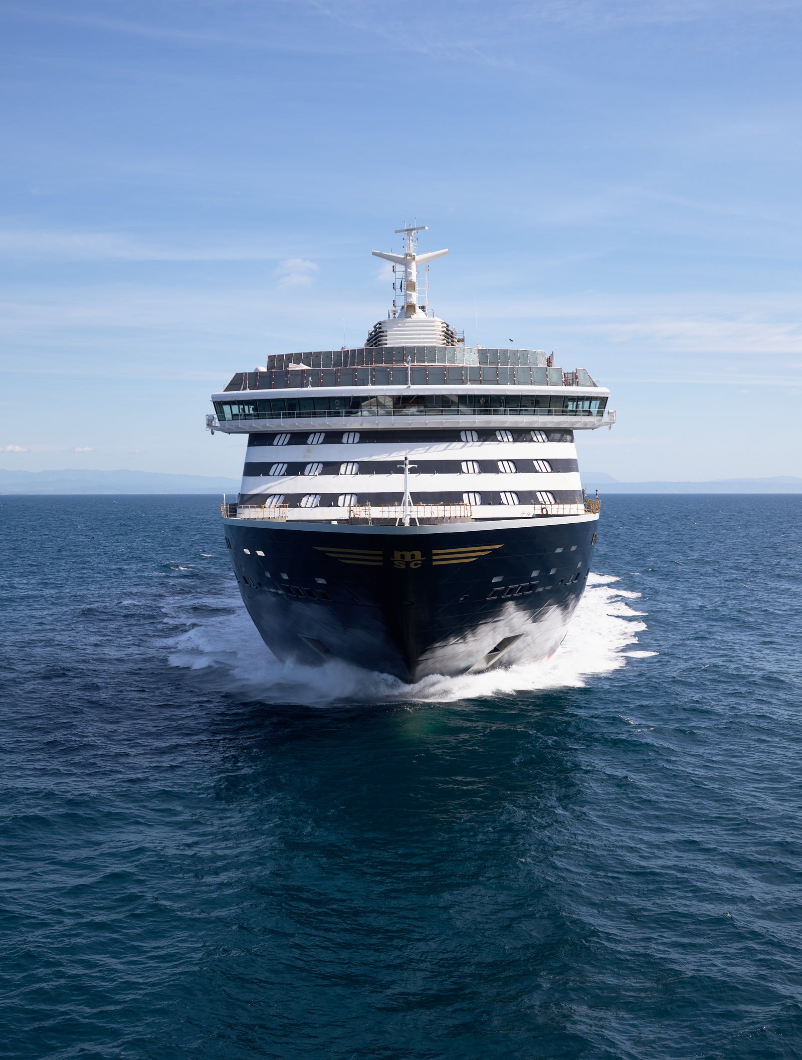 Fincantieri | Group - Business - Products - Cruise Ships - Explora I: Front view of luxury cruise ship in operation, dark hull contrasting with waves.