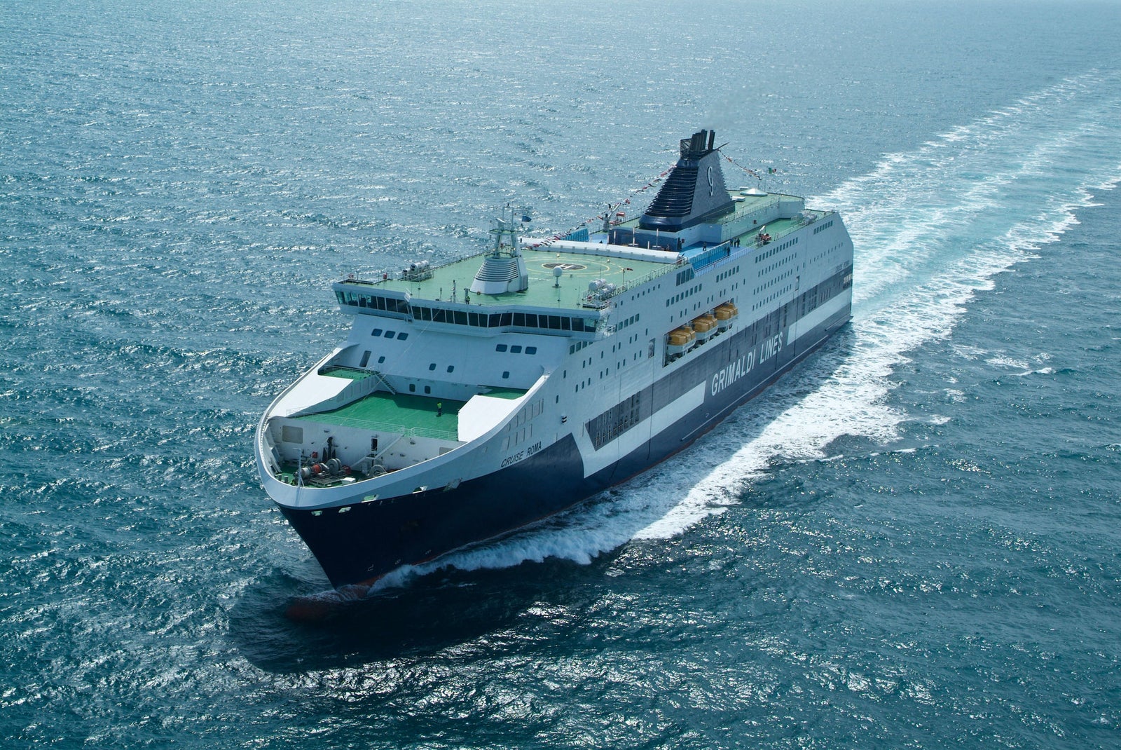 Prodotto - Traghetto Cruise Roma Grimaldi Lines: Vista laterale della nave operativa in navigazione, scafo con nome CRUISE ROMA visibile, ampio ponte e design moderno, ambiente marittimo sereno.