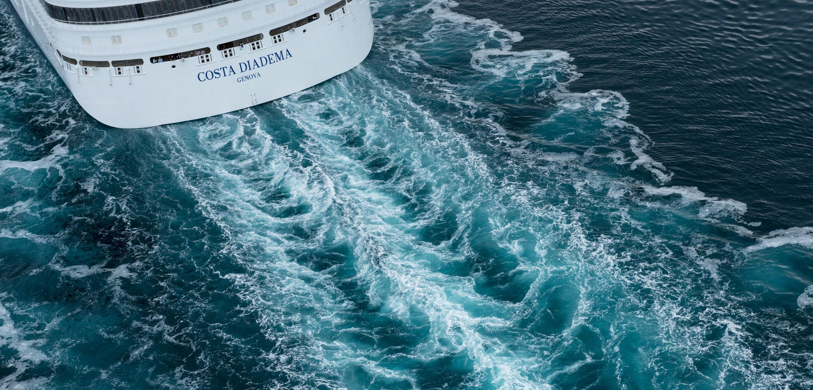 Fincantieri | Group - Business - Products - Cruise Ships - Costa Diadema: View of Costa Diadema cruise ship in operation navigating open sea, visible white wake, ship name readable on stern.