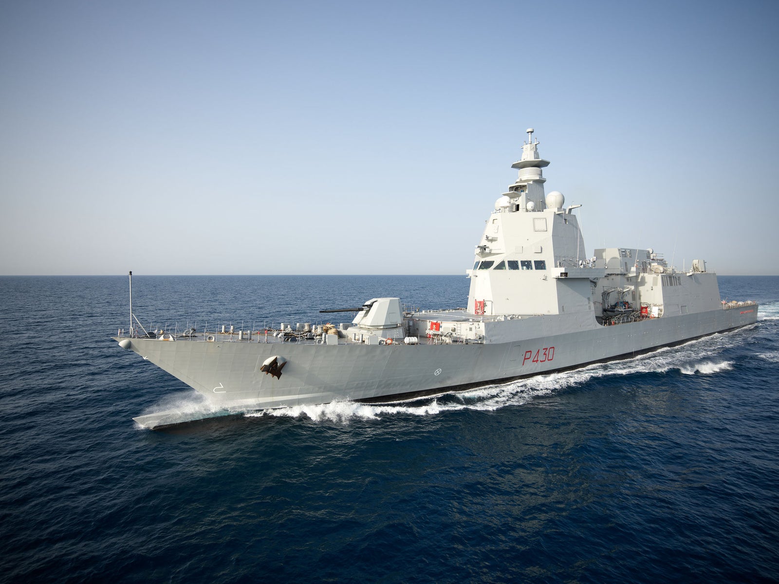 Fincantieri | Group - Business - Products - Defence Vessels - Frigates - Thaon de Revel class: Side view of operational ship underway, modern hull with number P430 visible, distant land background.