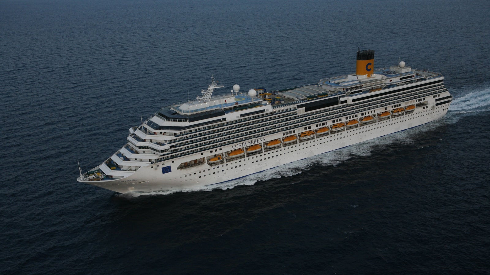 Fincantieri | Group - Business - Products - Cruise Ships - Costa Serena: Large operational cruise ship navigating open sea, hull with multiple passenger decks and distinctive yellow funnel with blue 'C' logo.