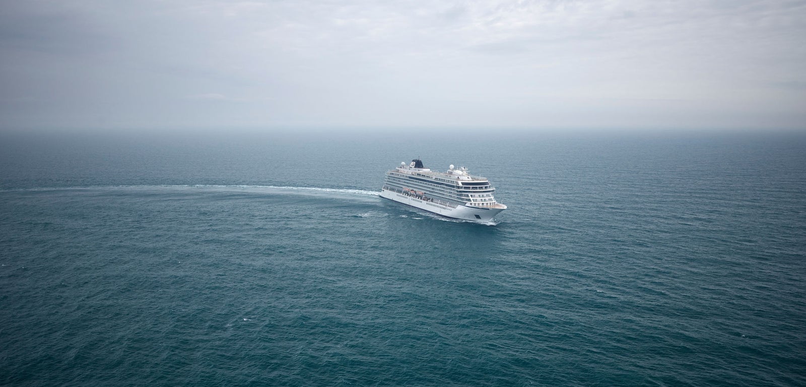  Fincantieri | Group - Business - Products - Cruise Ships - Viking Mars: Spacious cruise ship in operation navigating vast open ocean under cloudy sky, surrounded by calm waters, serene atmosphere emphasizing maritime grandeur and sea expanse.