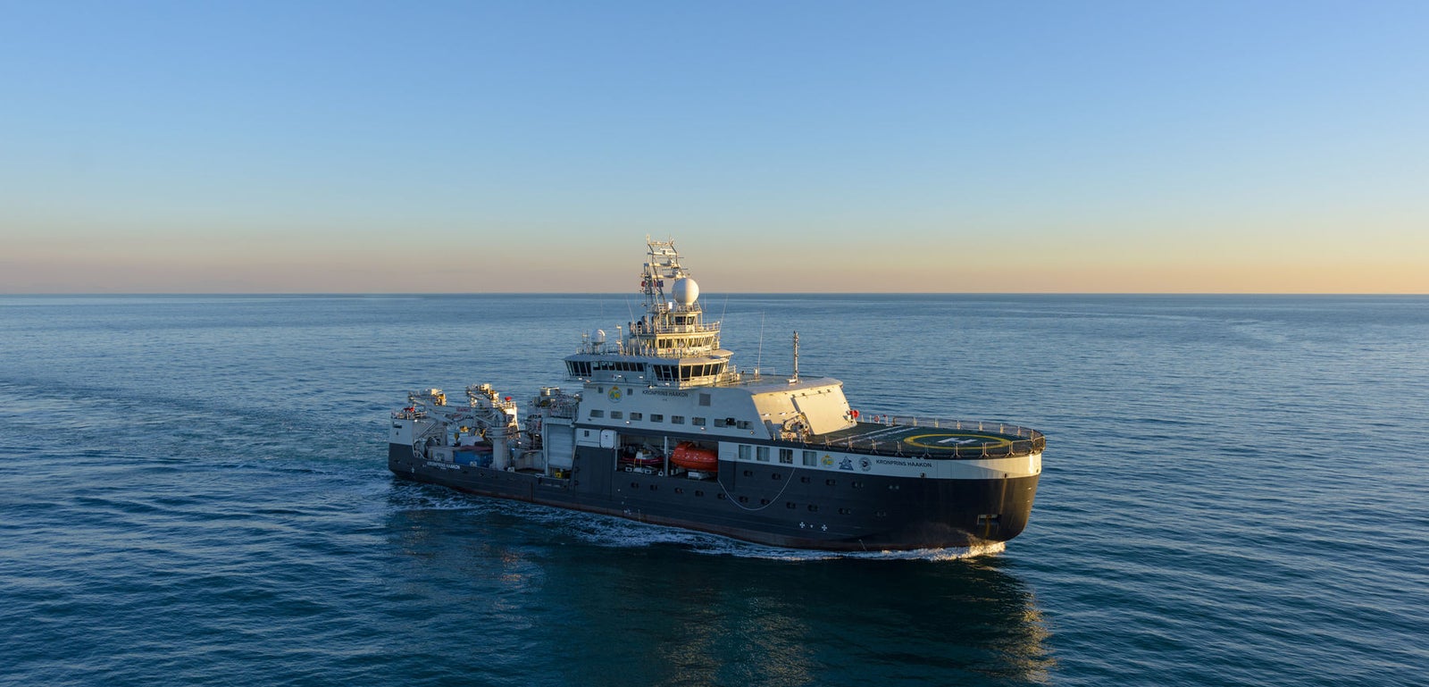 Prodotto - Nave da Ricerca Polare: Vista laterale della nave operativa in navigazione al tramonto, struttura robusta con attrezzature e dettagli di coperta visibili, riflessi sull’oceano esteso.